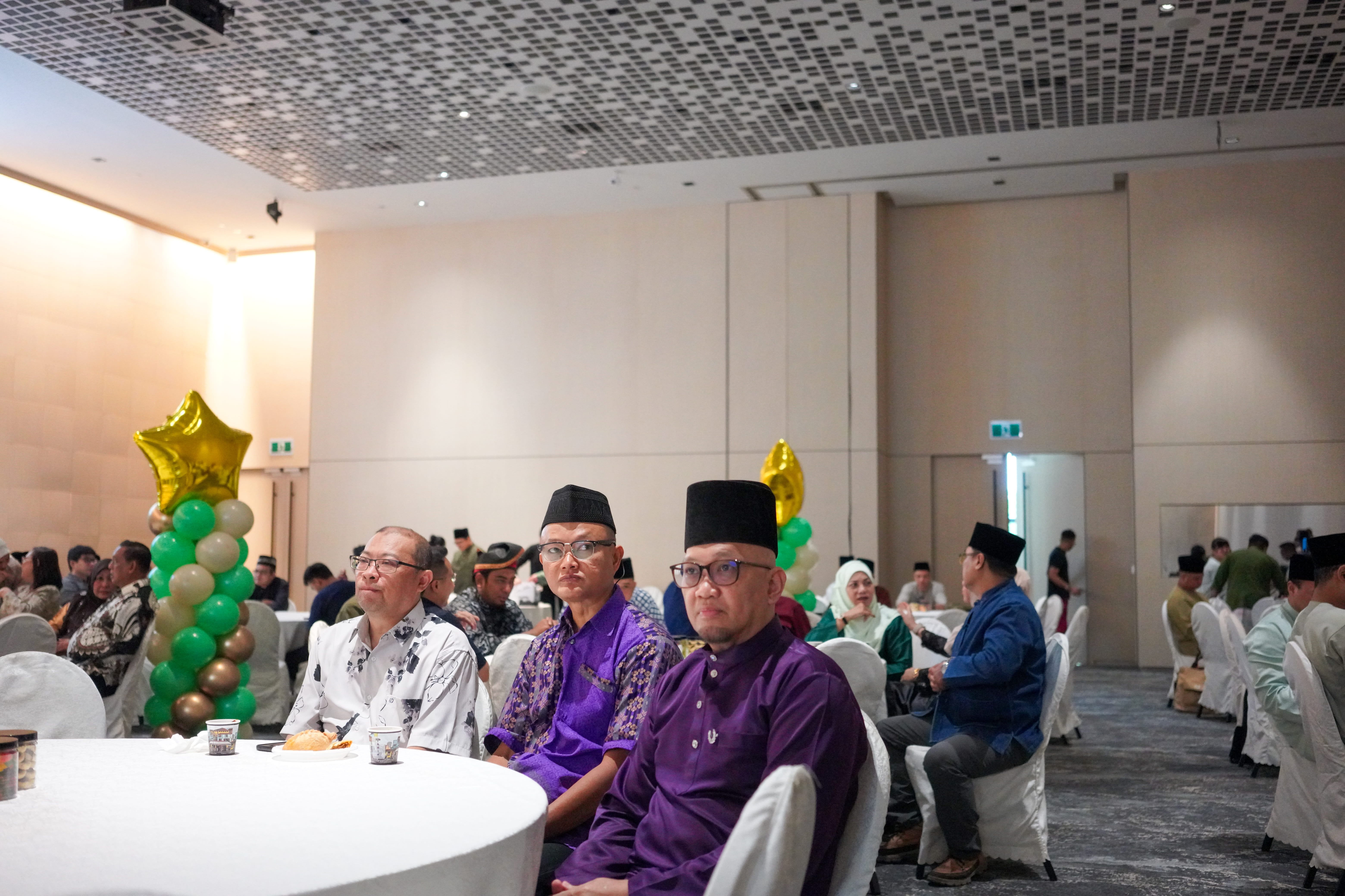 Guests seated at round tables in the function hall listening to the proceedings of the 69th Annual General Meeting.